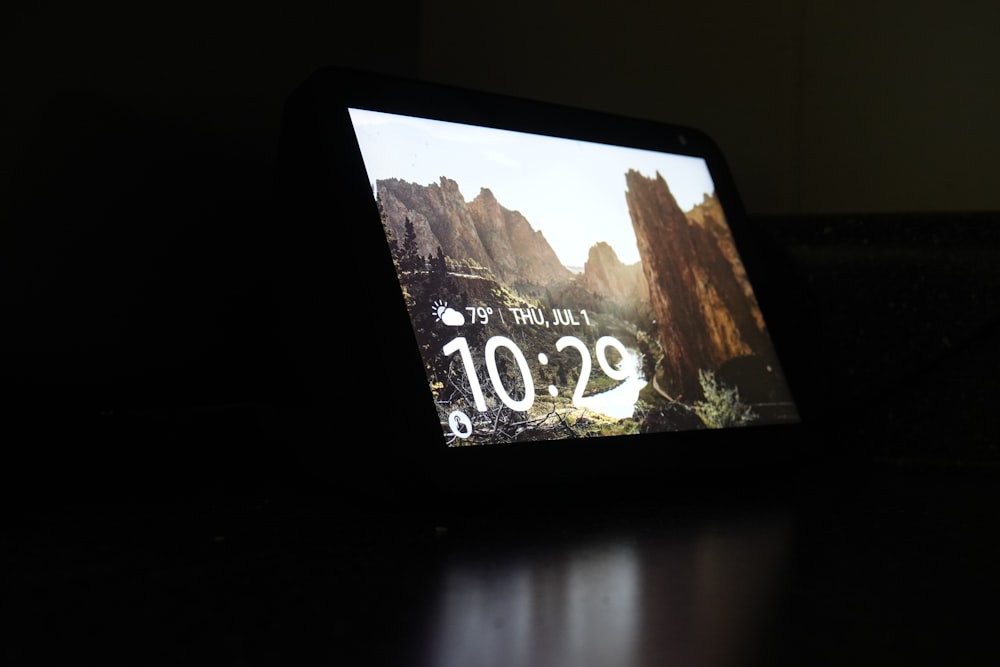 black tablet computer turned on displaying 12 00