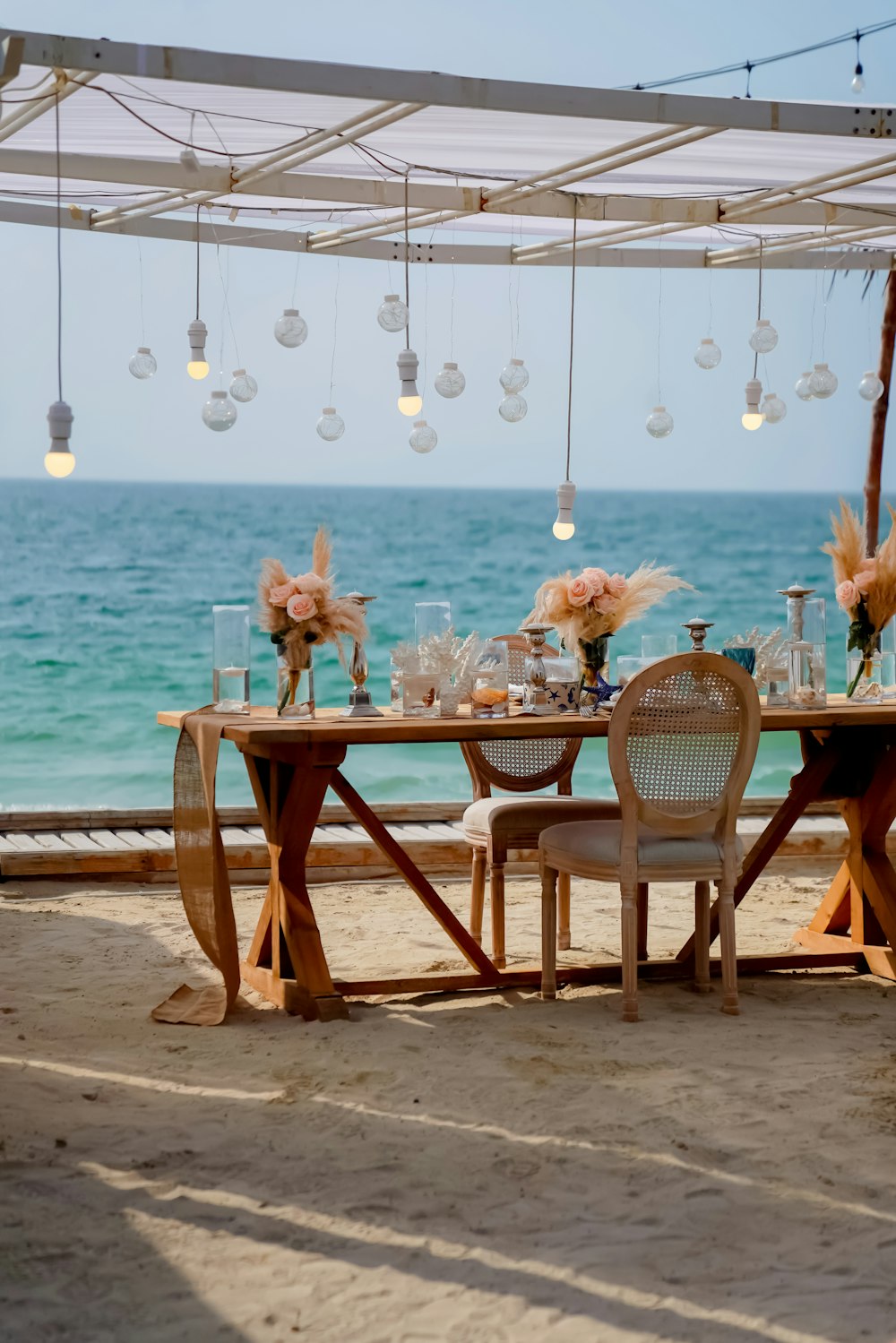 brown wooden table with chairs on beach during daytime