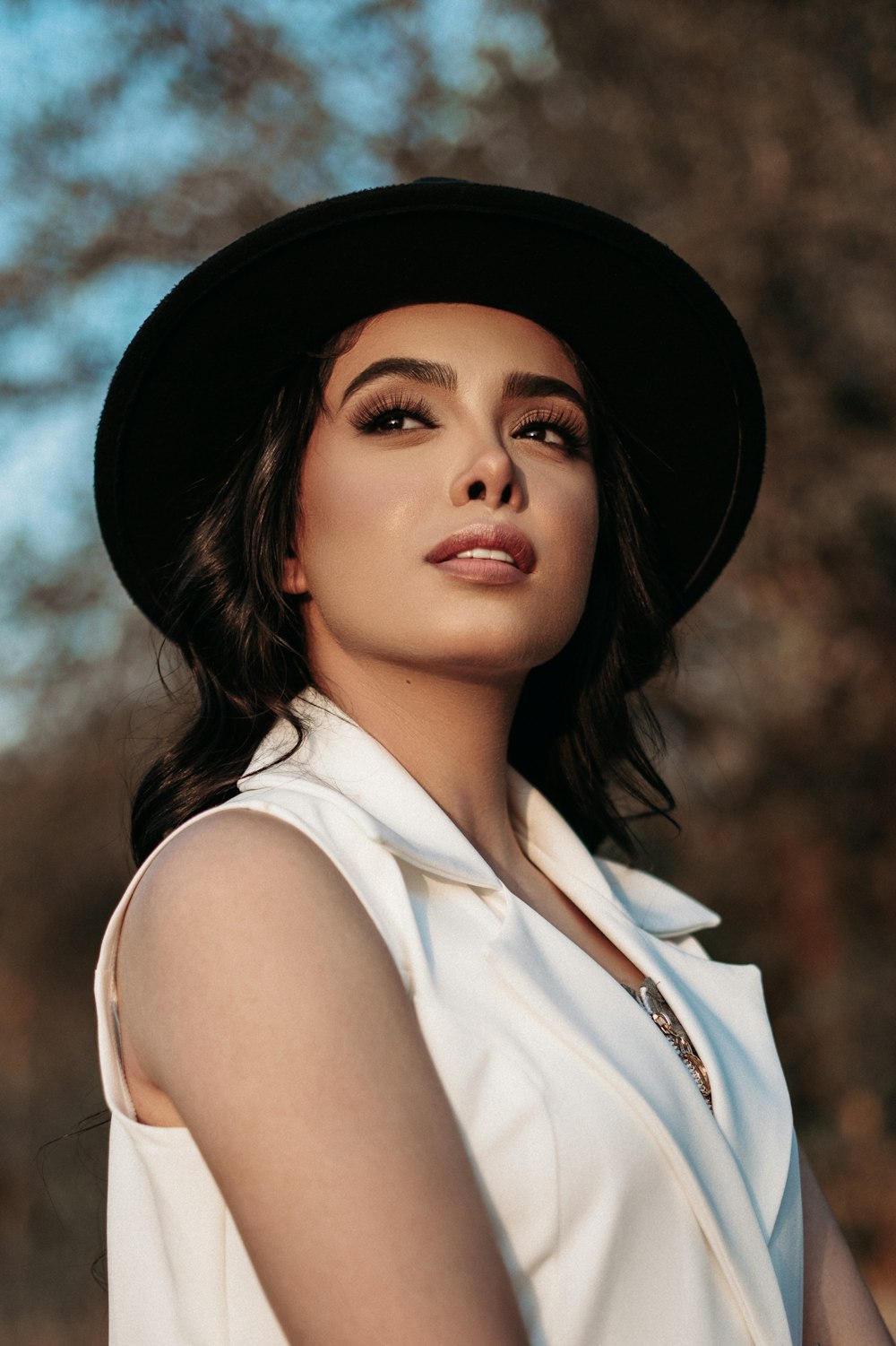 woman in white sleeveless shirt wearing black hat