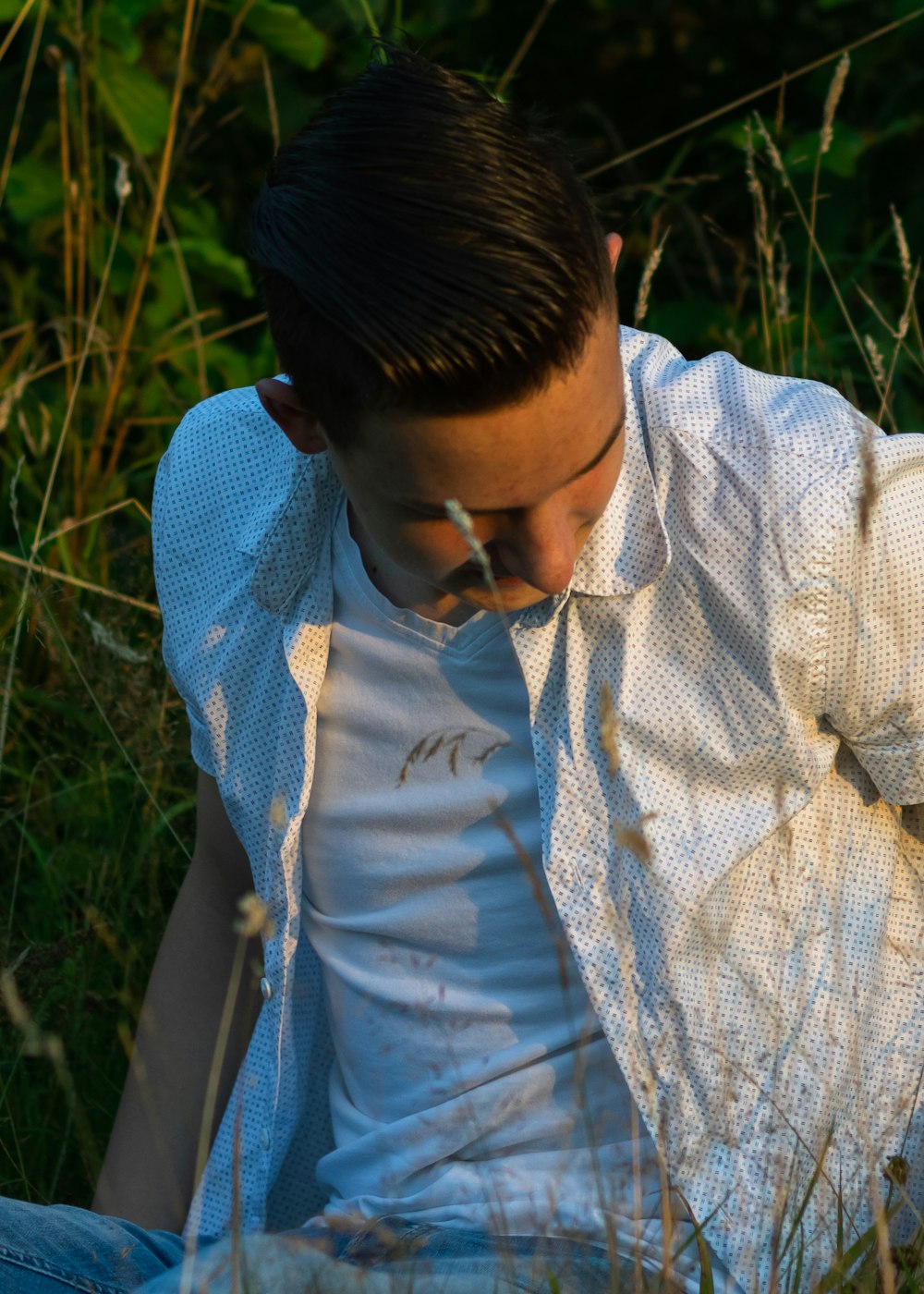 a man sitting in a field of tall grass