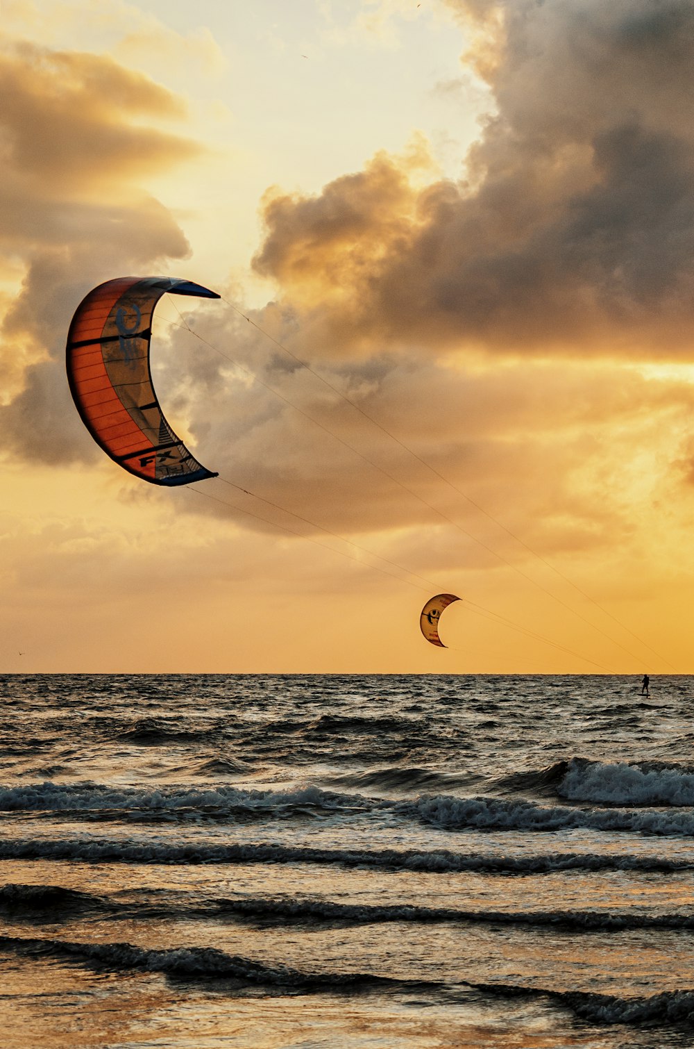 personne surfant sur la mer au coucher du soleil