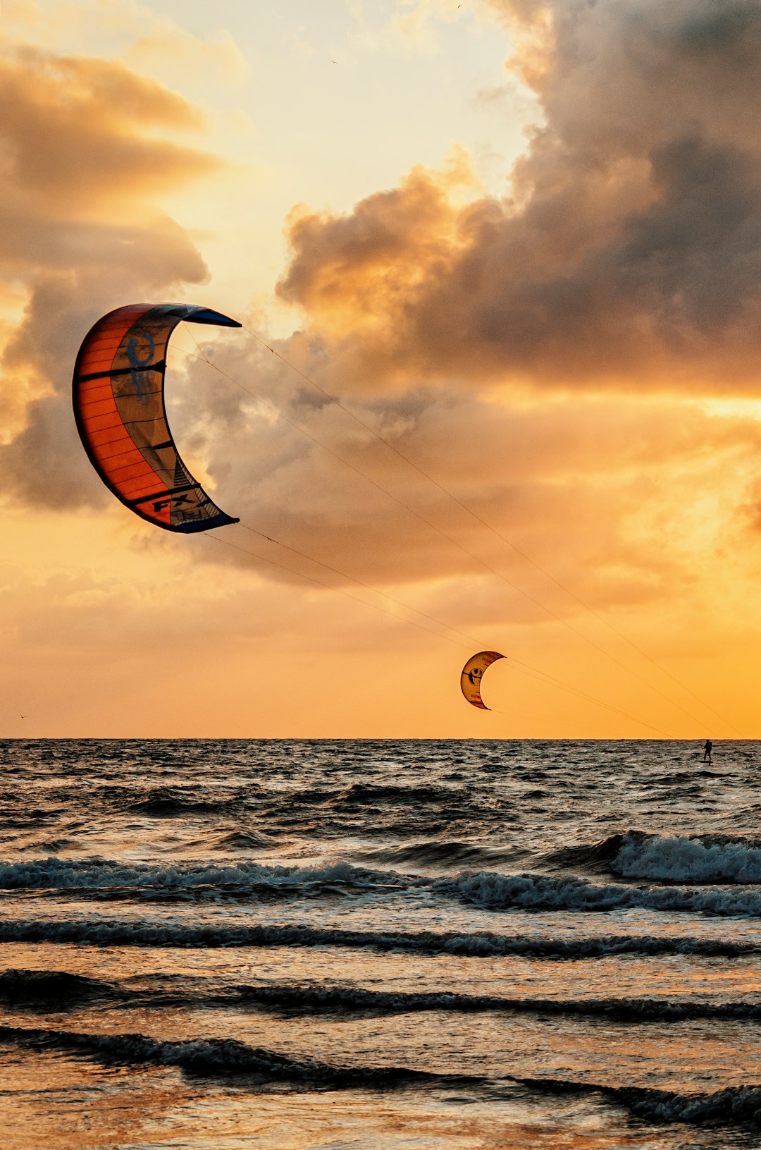 person surfing on sea during sunset