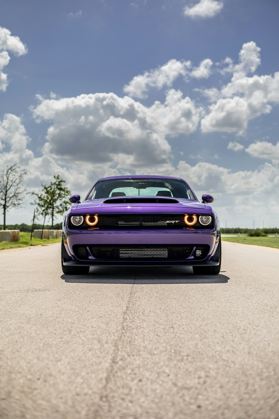 black chevrolet camaro on road under blue sky during daytime