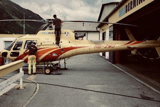 woman in red and white dress standing beside yellow and red airplane during daytime