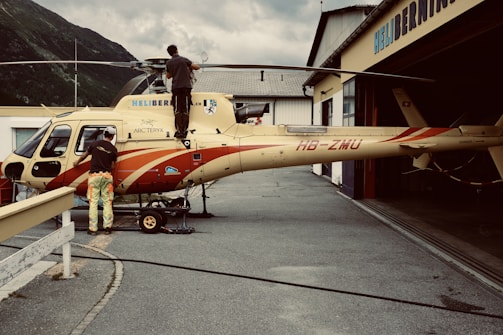 woman in red and white dress standing beside yellow and red airplane during daytime