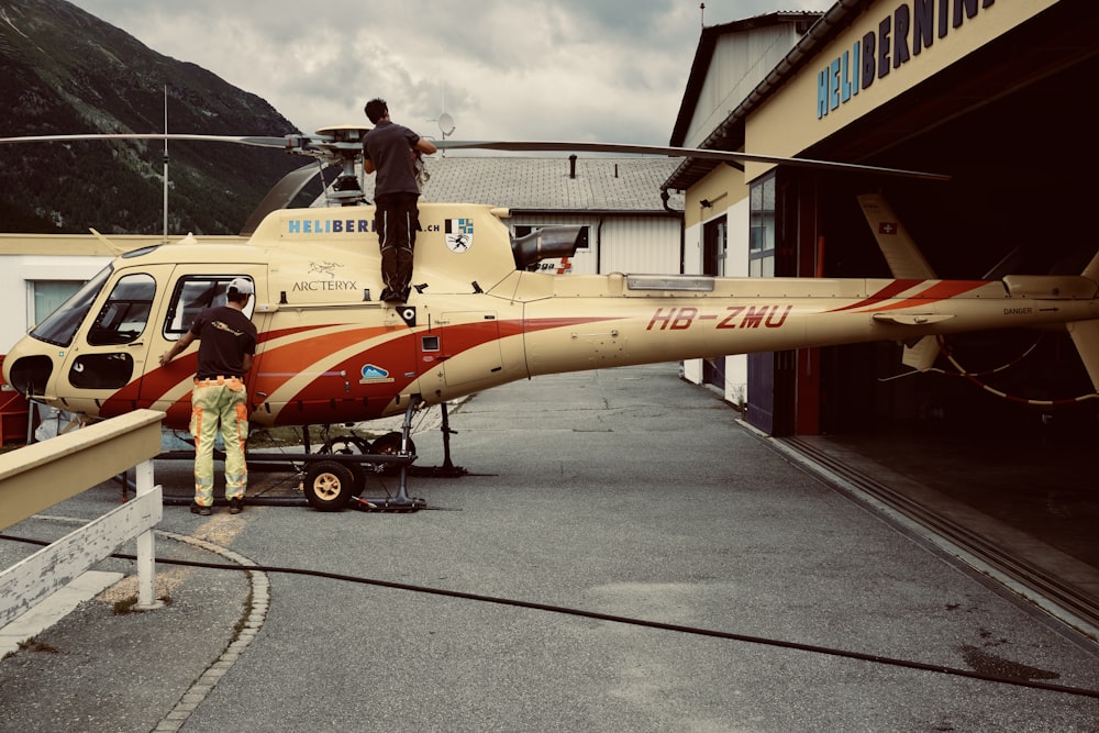 woman in red and white dress standing beside yellow and red airplane during daytime