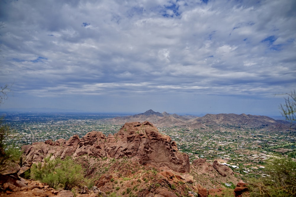 brown rocky mountain near blue sea under blue and white cloudy sky during daytime