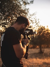 man in black t-shirt holding black dslr camera