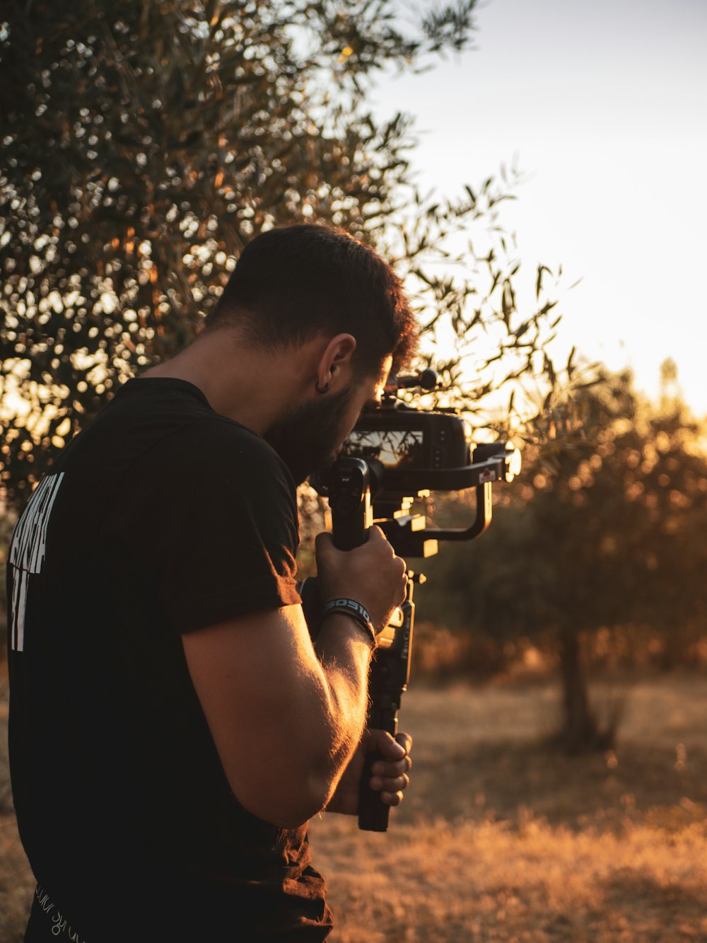 man in black t-shirt holding black dslr camera