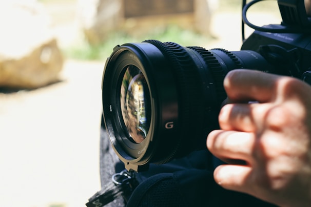 Close-up of a photographer adjusting a professional camera lens.