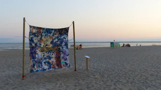 Wall art featuring a serene beach sunset with soft sandy neutrals and ocean blues, framed and hanging in a bright room.