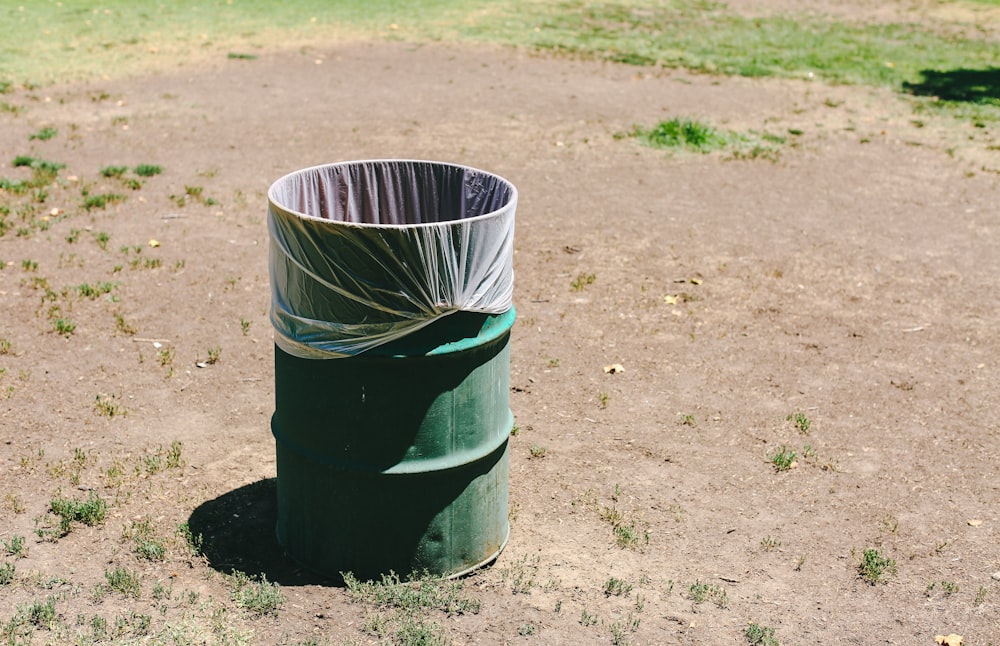 Cubo de basura negro sobre suelo de hormigón gris