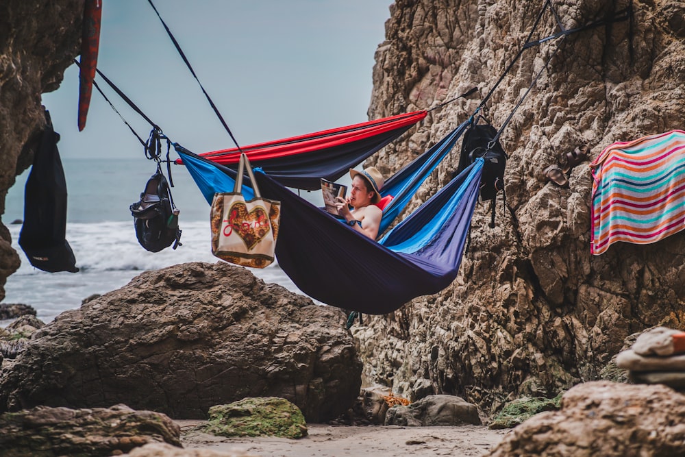 woman in black and white tank top sitting on red hammock