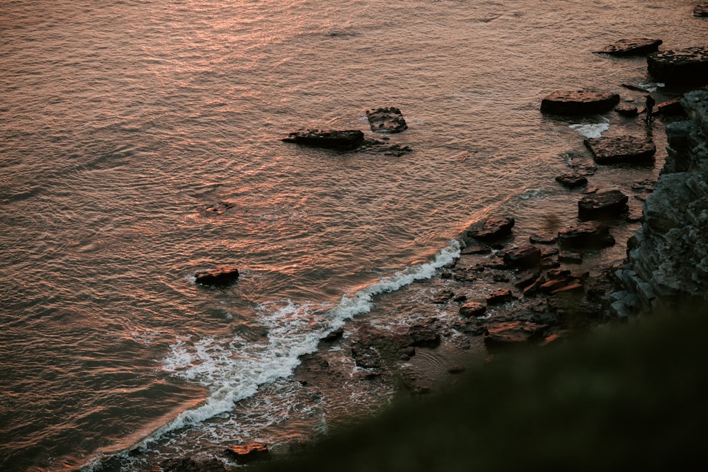 vista aérea das ondas do oceano batendo em rochas durante o dia