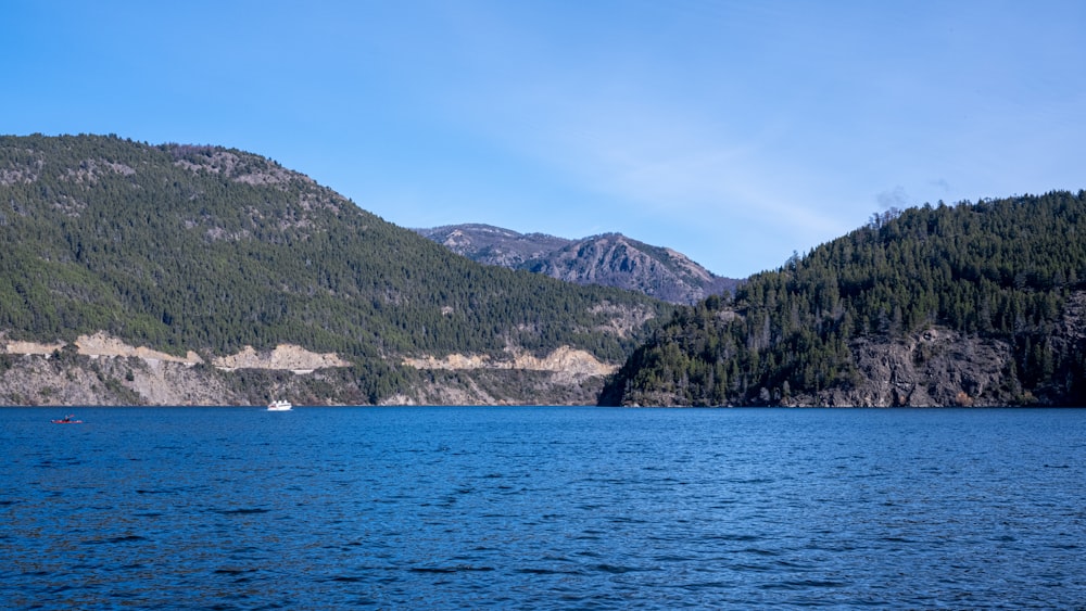 green and brown mountain beside body of water during daytime