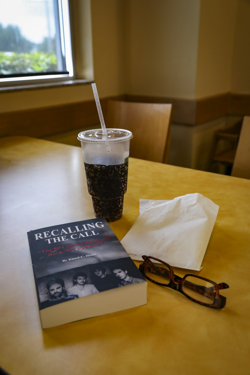 black framed eyeglasses beside black and white labeled book