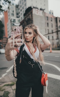 woman in black sleeveless dress holding her hair
