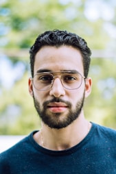 man in blue crew neck shirt wearing black framed eyeglasses