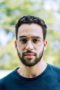 man in blue crew neck shirt wearing black framed eyeglasses