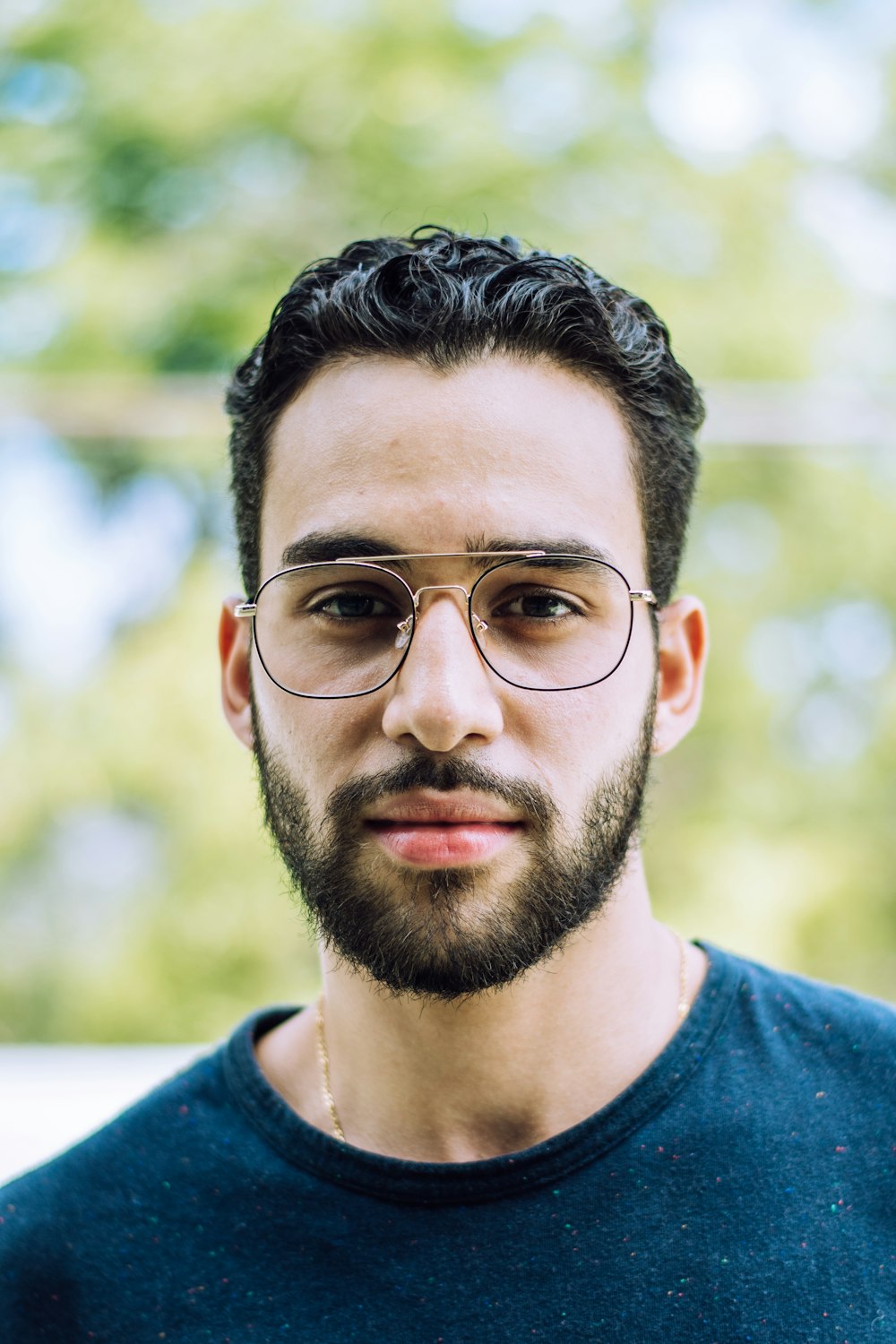 man in blue crew neck shirt wearing black framed eyeglasses