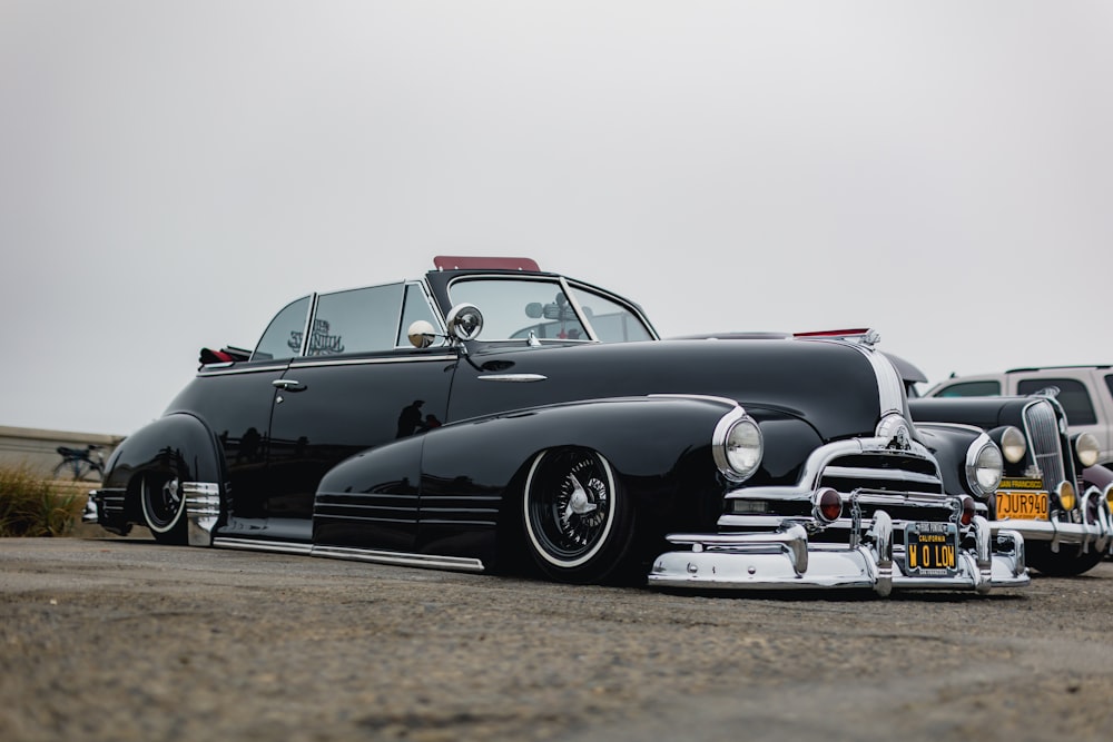 black vintage car on gray asphalt road during daytime