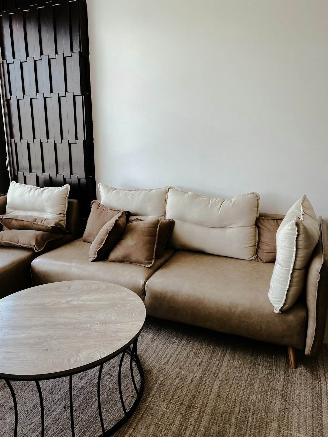 brown cushion couch beside black wooden round table