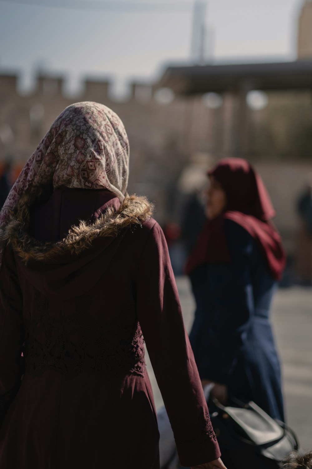 Donna in hijab bianco e nero in piedi sulla strada durante il giorno