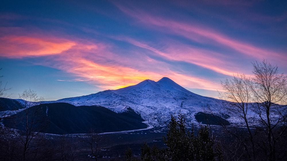 snow covered mountain during sunset