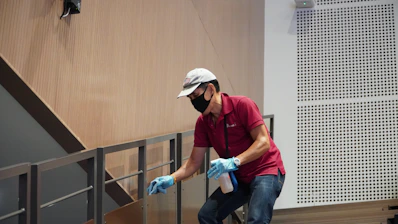 man in green polo shirt and blue denim jeans sitting on chair