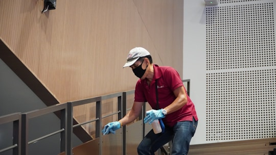 man in green polo shirt and blue denim jeans sitting on chair