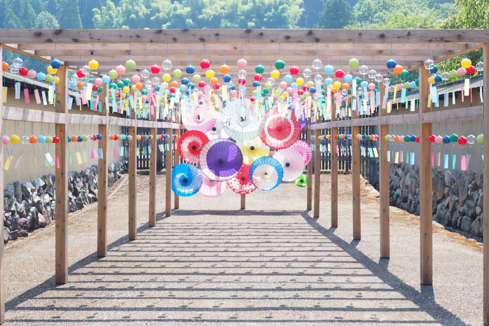 Menschen, die tagsüber auf einer Holzbrücke mit Ballons auf der Spitze spazieren gehen