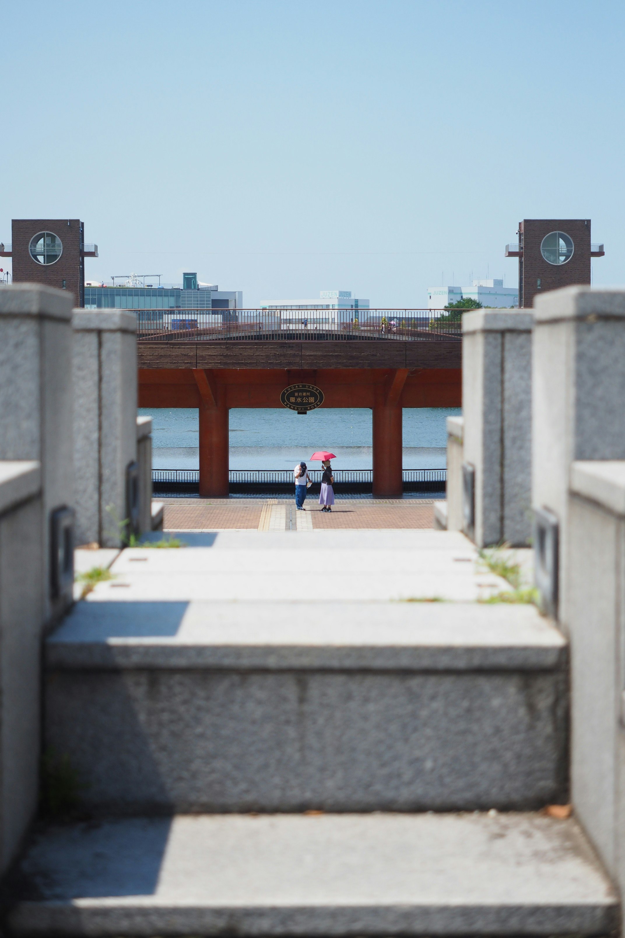 man in blue shirt and black pants walking on gray concrete pathway during daytime