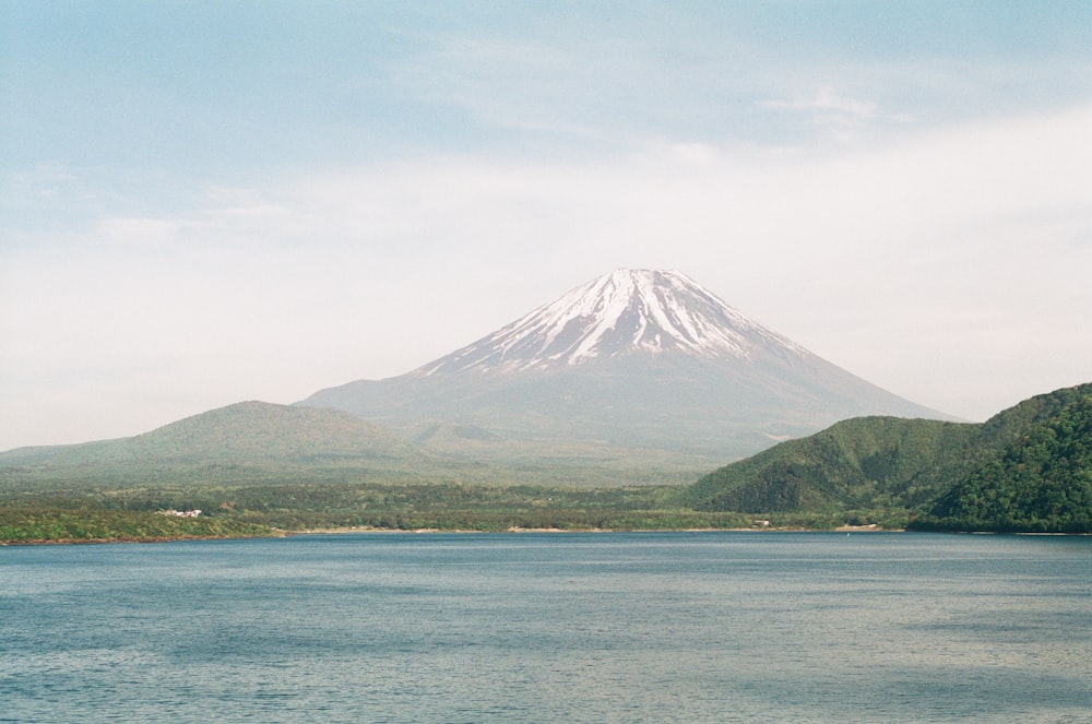 white and green mountain near body of water during daytime