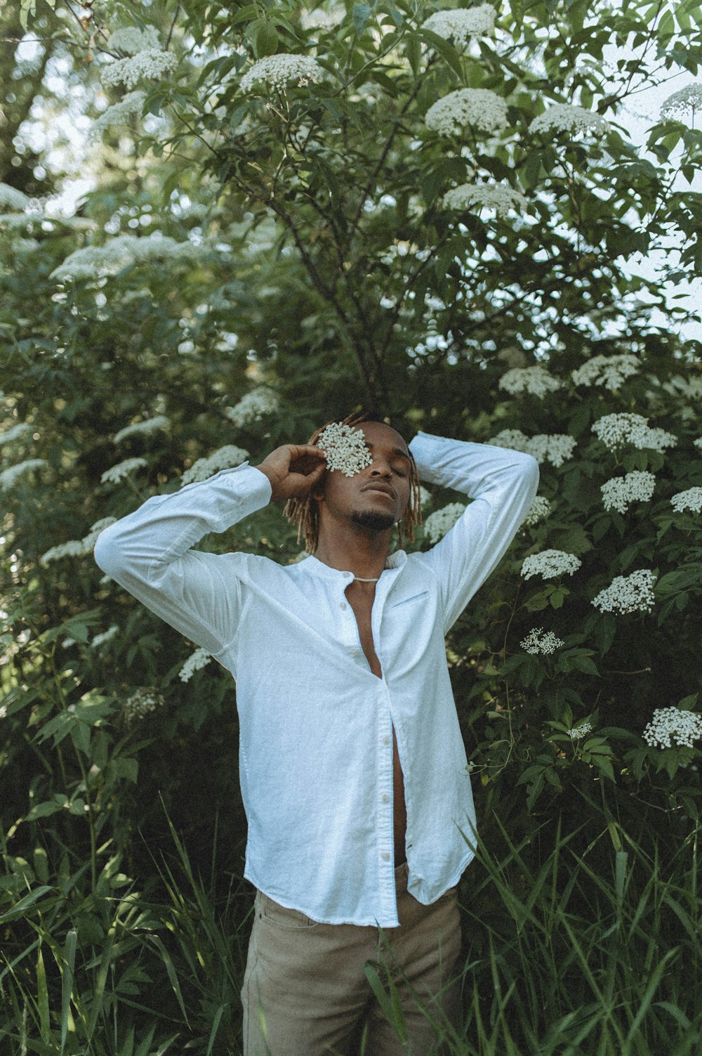 man in white dress shirt standing near green plants during daytime