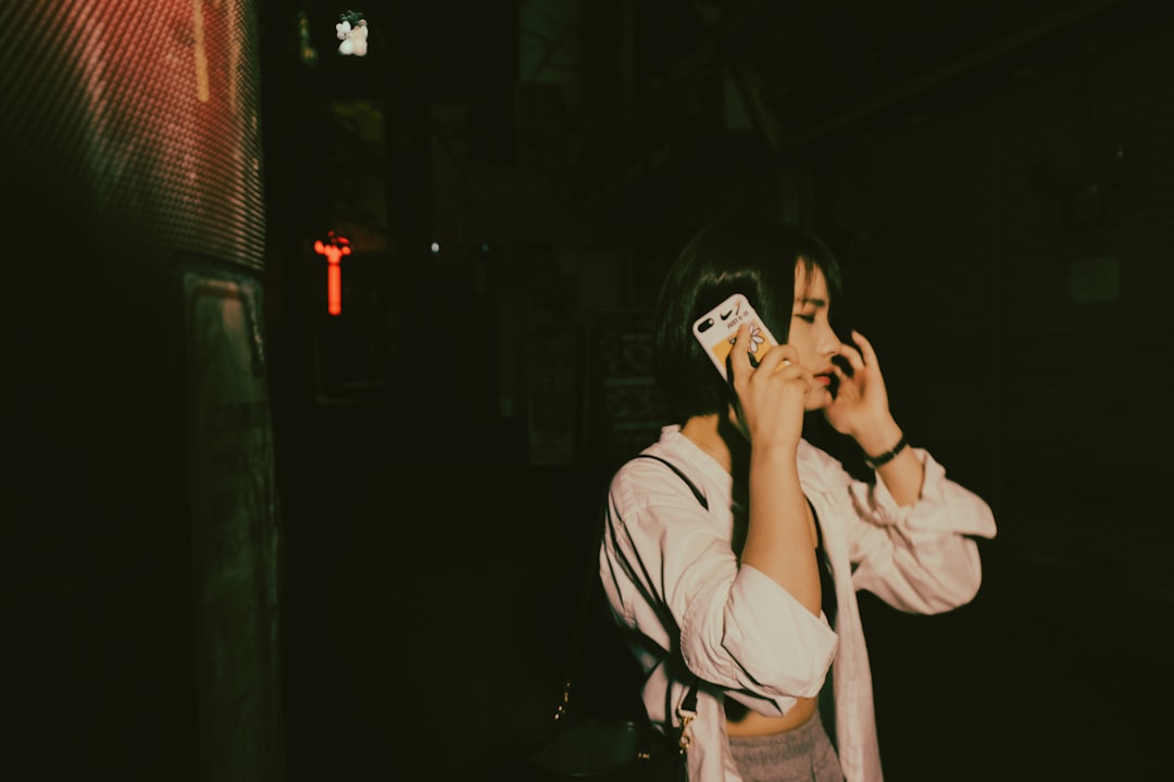 woman in white coat holding smartphone