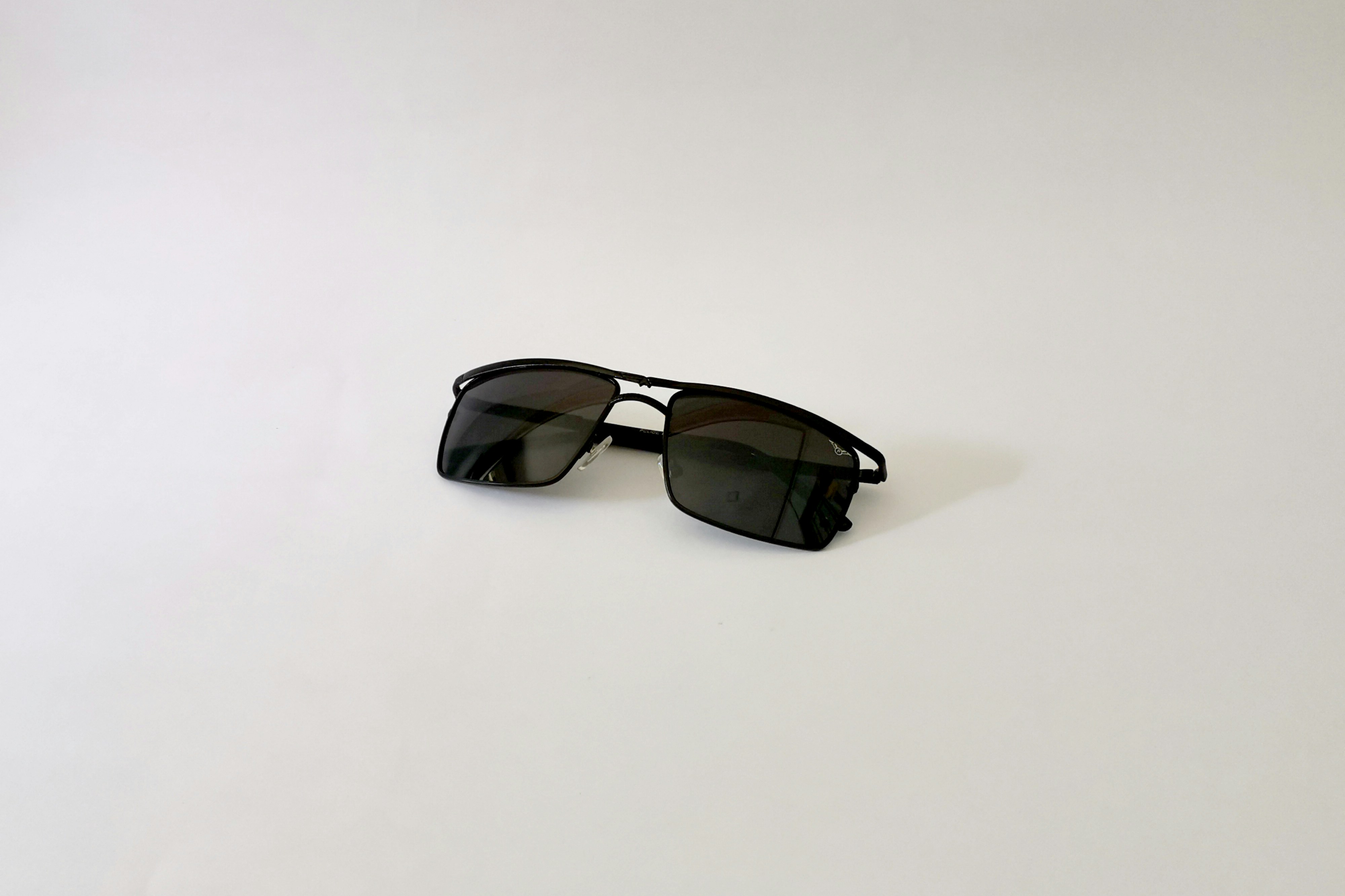 black framed sunglasses on white table
