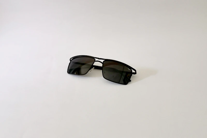 classic black sunglasses on a white table