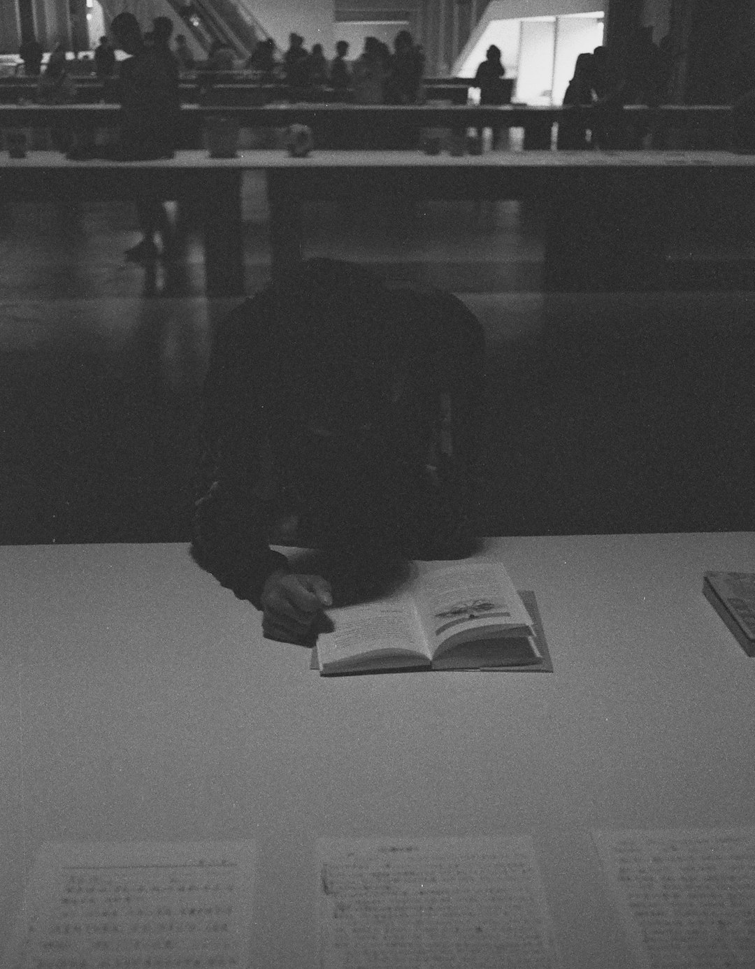grayscale photo of person reading book