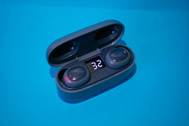A pair of wireless earbuds in a compact charging case with LED indicators.