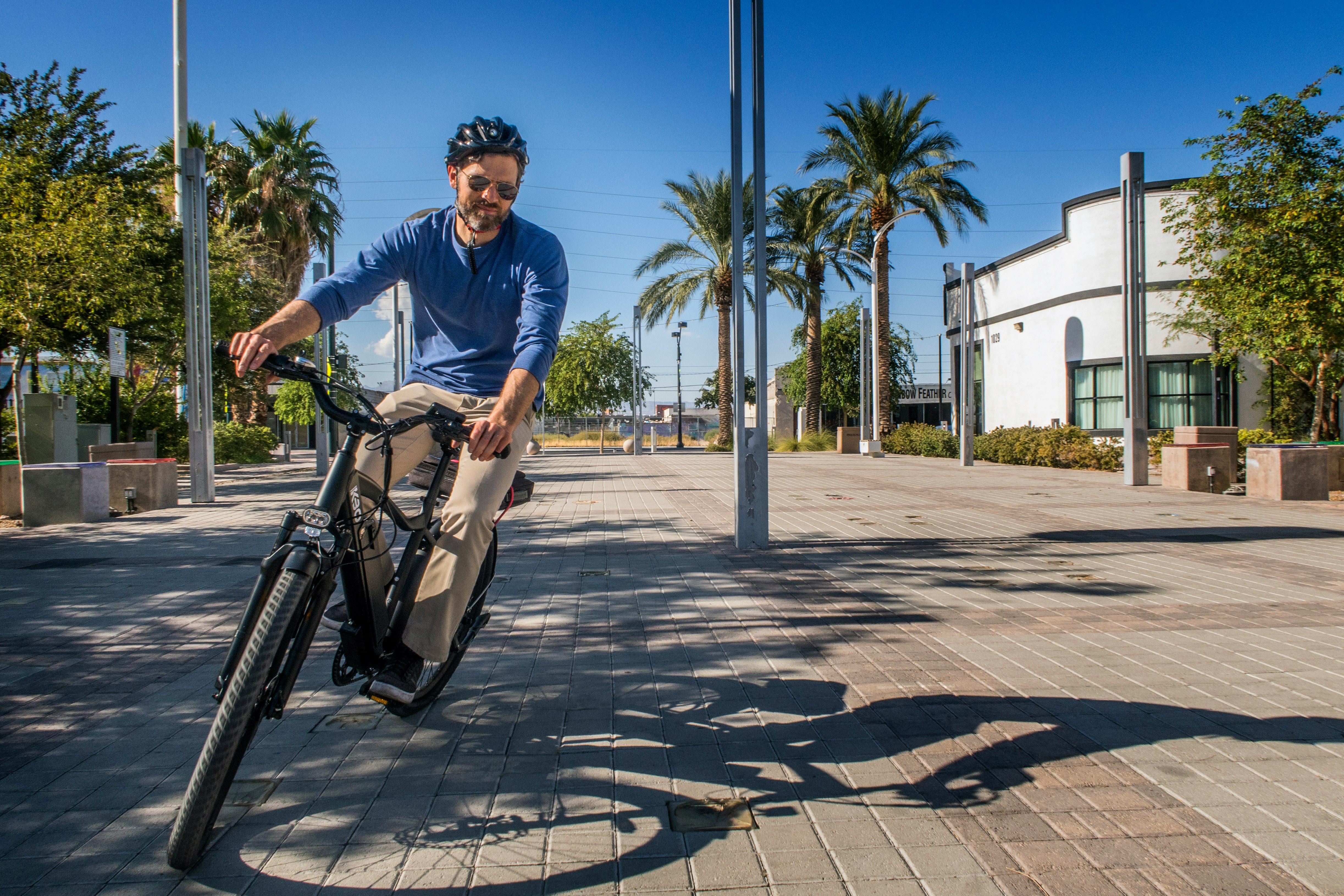 man in blue polo shirt riding bicycle during daytime