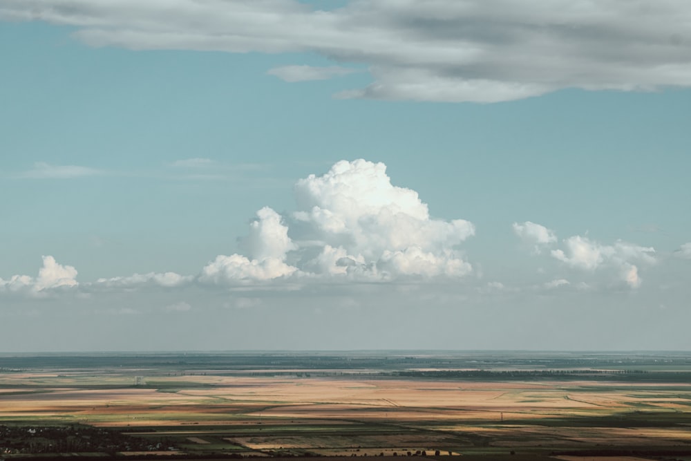 white clouds over brown field