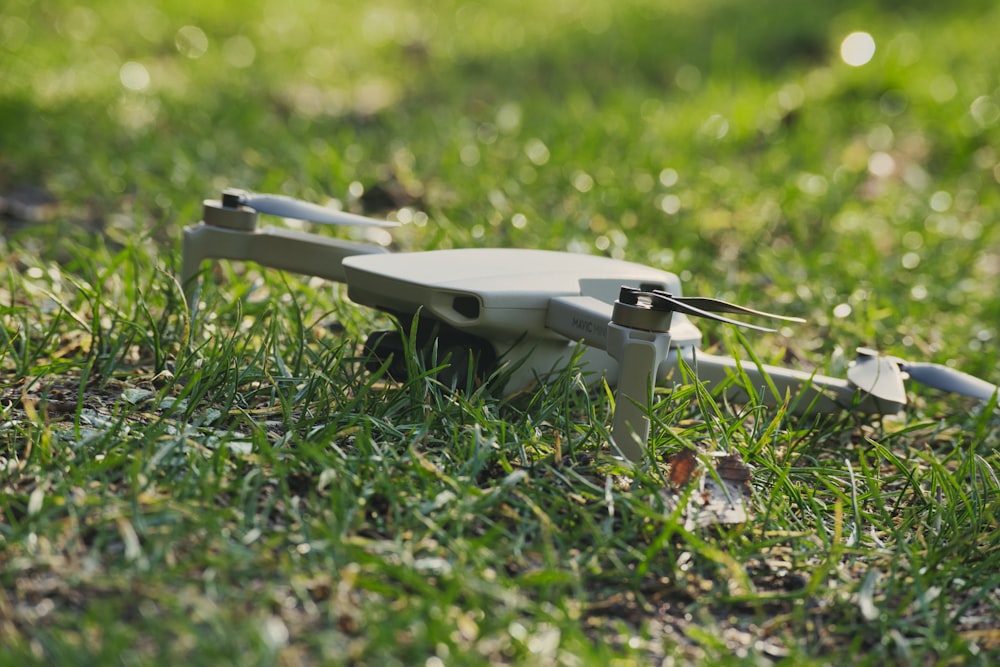 white and black drone on green grass during daytime