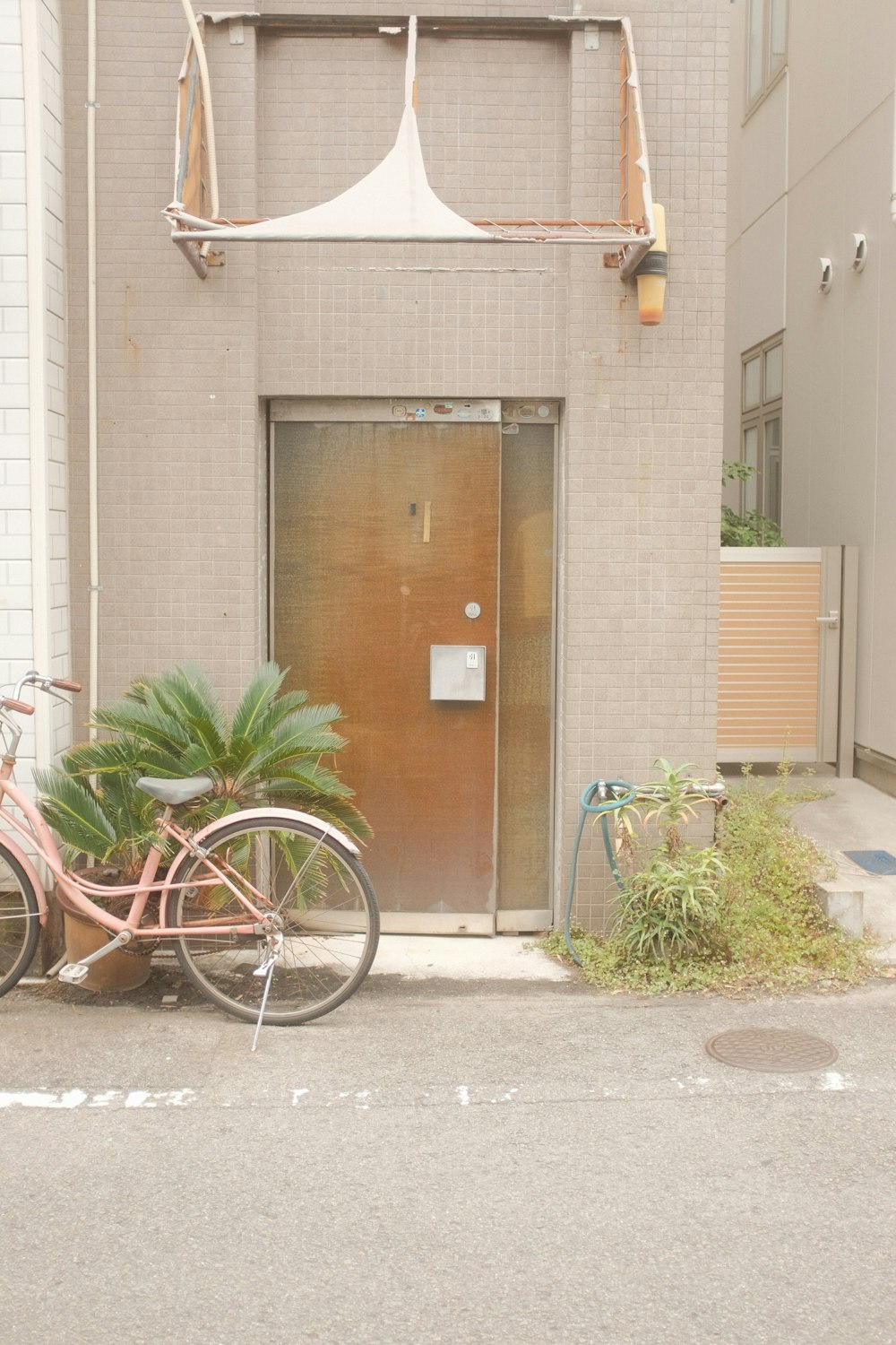 white city bike parked beside brown wooden door