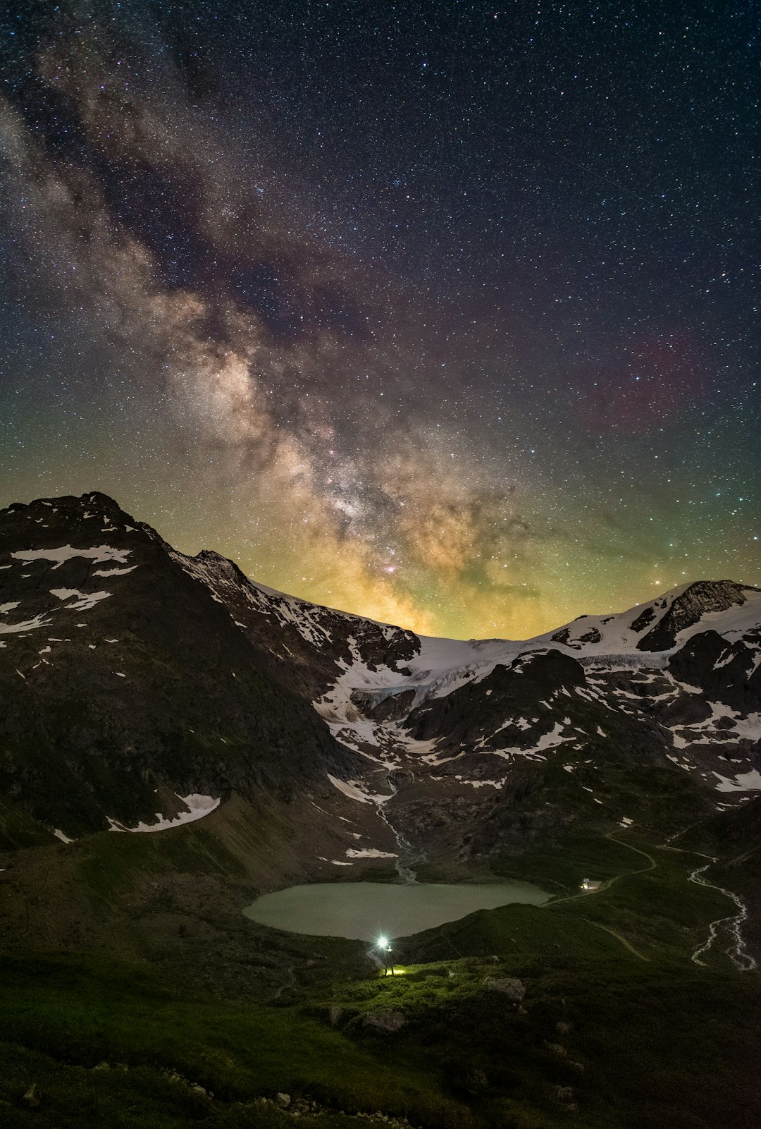 lake in the middle of mountains under starry night