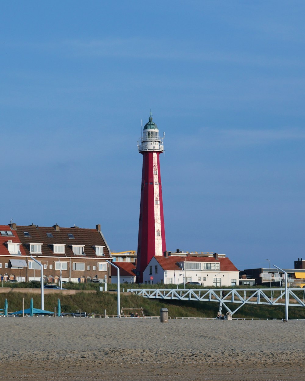 red and white lighthouse near brown concrete building during daytime