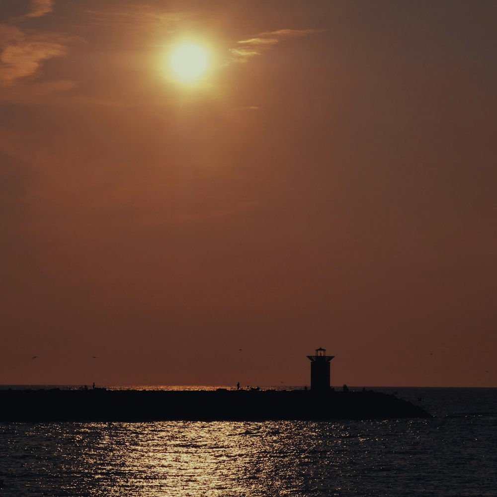 silhouette of lighthouse during sunset