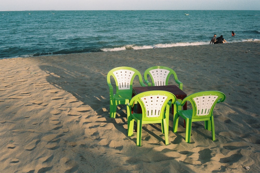 green plastic chairs on beach during daytime