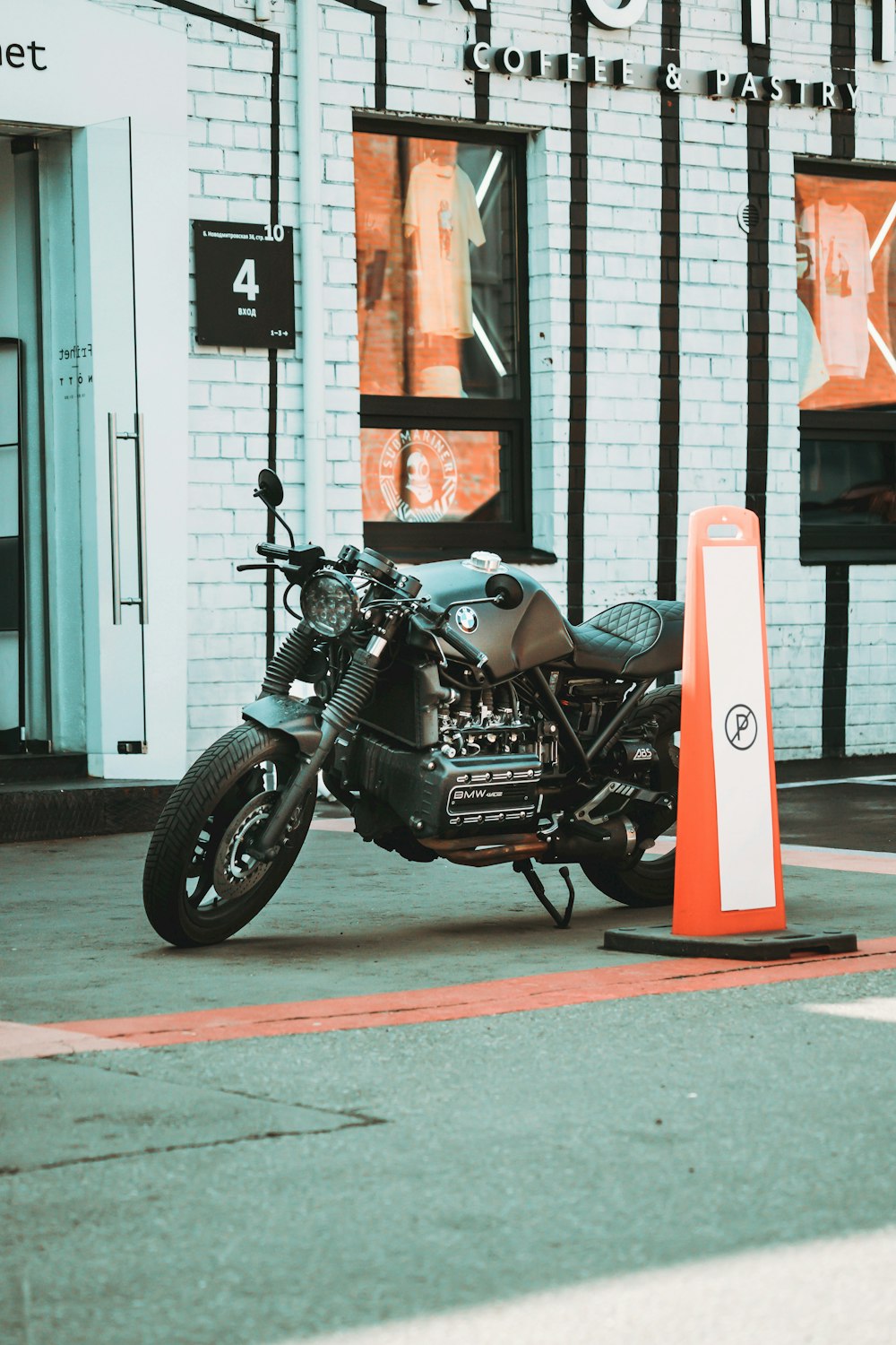 black and silver cruiser motorcycle parked beside red and white traffic cone