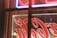 Close-up of a professional installing a vibrant custom business sign on a storefront exterior.