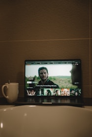 black flat screen tv turned on displaying man in black suit